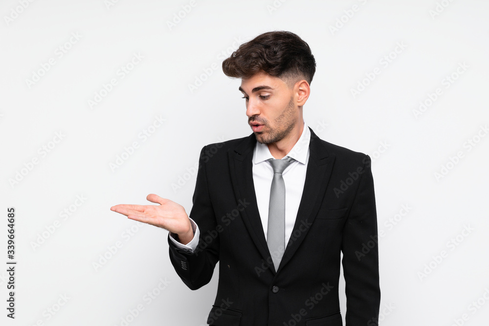 Young businessman over isolated white background holding copyspace imaginary on the palm Young businessman over isolated white background holding copyspace imaginary on the palm