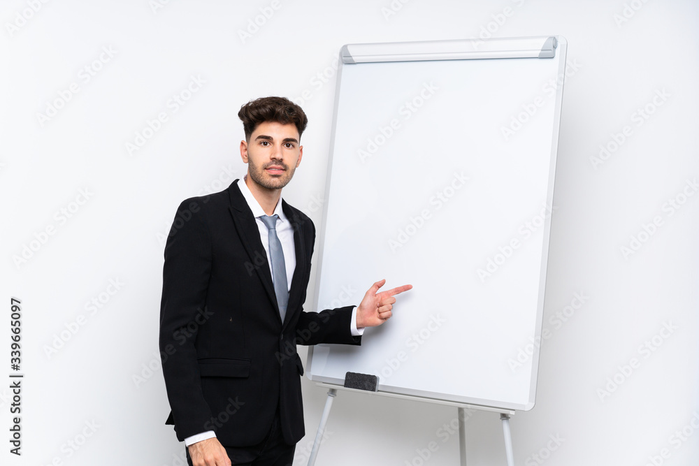 Young businessman giving a presentation on white board giving a presentation on white board and pointing it Young businessman giving a presentation on white board giving a presentation on white board and pointing it