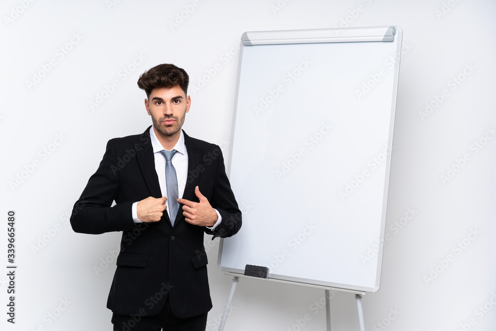 Young businessman giving a presentation on white board with surprise facial expression Young businessman giving a presentation on white board with surprise facial expression