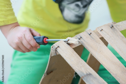 Mit Kindern Handwerken, mit Schraubenzieher Krampe entfernen photo