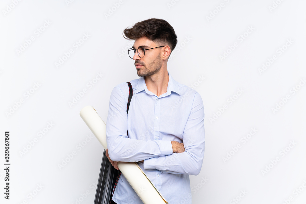 Young architect man over isolated white background looking side Young architect man over isolated white background looking side