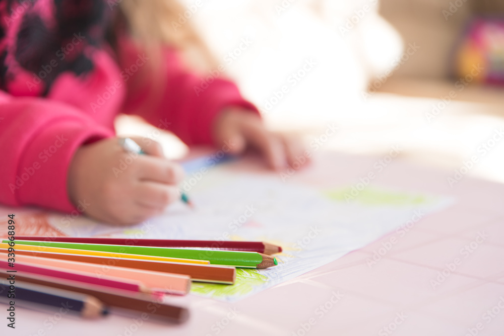 Color pencils lying on the table. Process of drawing by a little child, close up view. Soft background with copy space. Themes of child development, leisure and hobby Color pencils lying on the table. Process of drawing by a little child, close up view. Soft background with copy space. Themes of child development, leisure and hobby