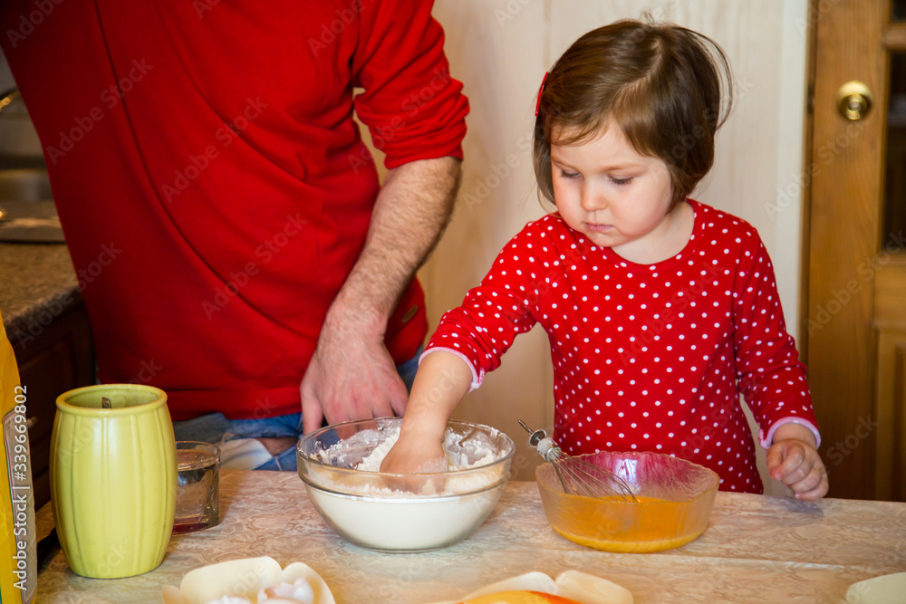 a cute little girl with blue eyes and red clothes is making cakes out of flour in the kitchen at home during the quarantine a cute little girl with blue eyes and red clothes is making cakes out of flour in the kitchen at home during the quarantine