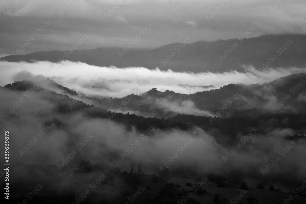 Obraz premium View landscape with silhouettes of mountains range with mist or covered by heavy fog