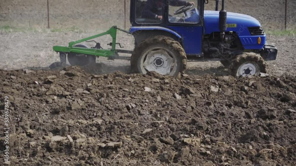 Tractor cultivates the land for planting of the earth. planting vegetables for having domestic food Tractor cultivates the land for planting of the earth. planting vegetables for having domestic food