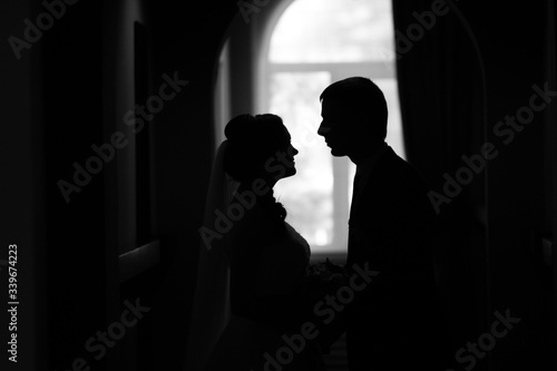 silhouette of a couple. the bride looks at the groom.