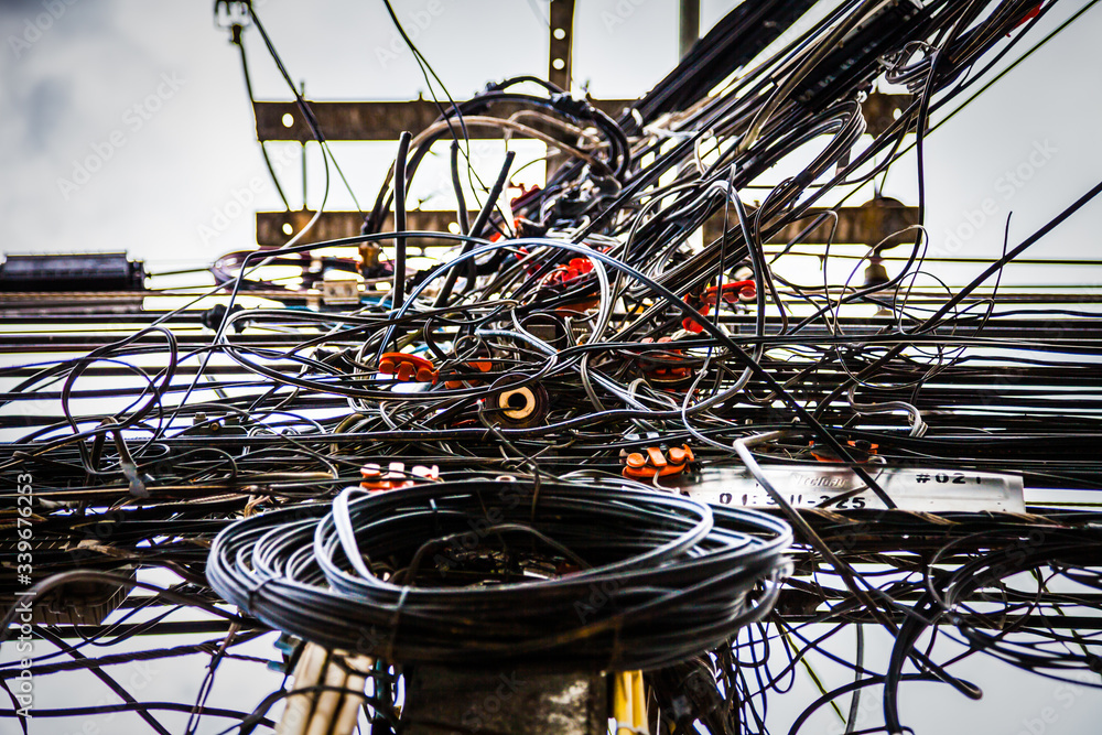 Obraz premium Tangled electrical wires on urban electric pole.