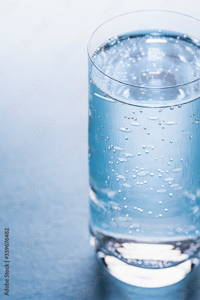 Glass of tonic water on blue background. Glass of tonic water on blue background.