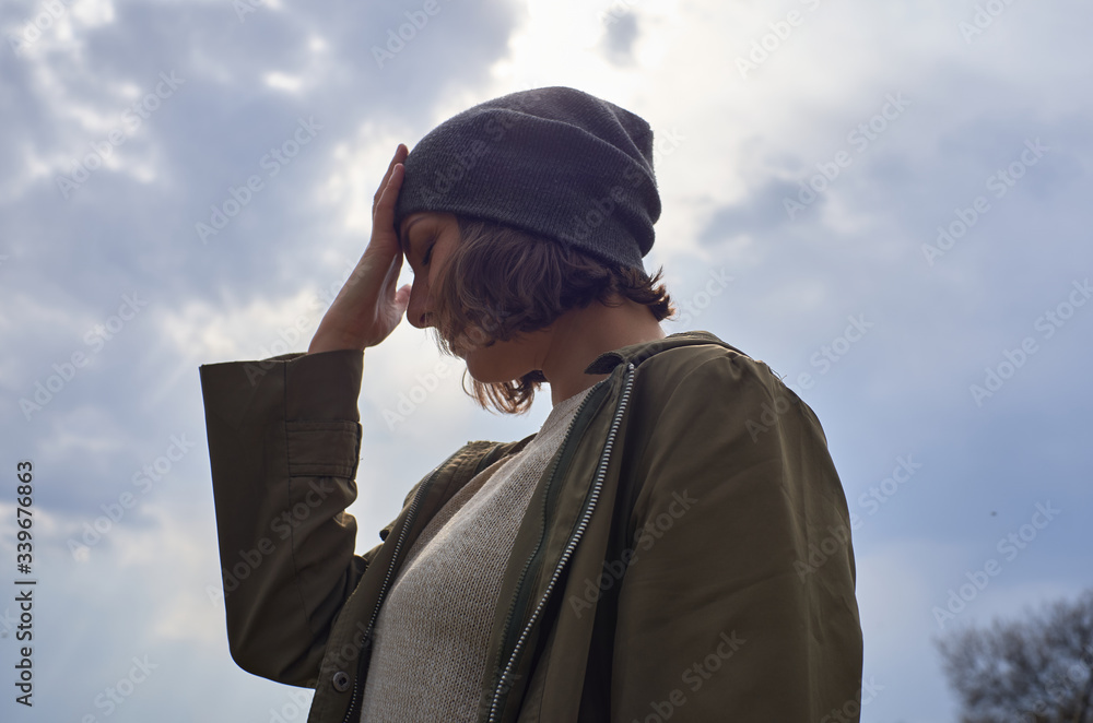 Beautiful girl in gray hat on sky background. Portrait of young woman freedom conception