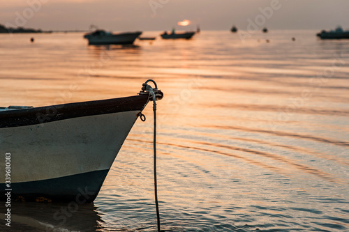 A small boat in a beach in cadiz at sunset