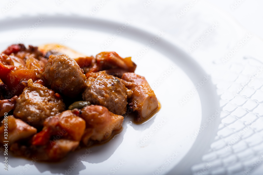 albóndigas con pulpo y patatas en salsa servidas en un plato blanco albóndigas con pulpo y patatas en salsa servidas en un plato blanco