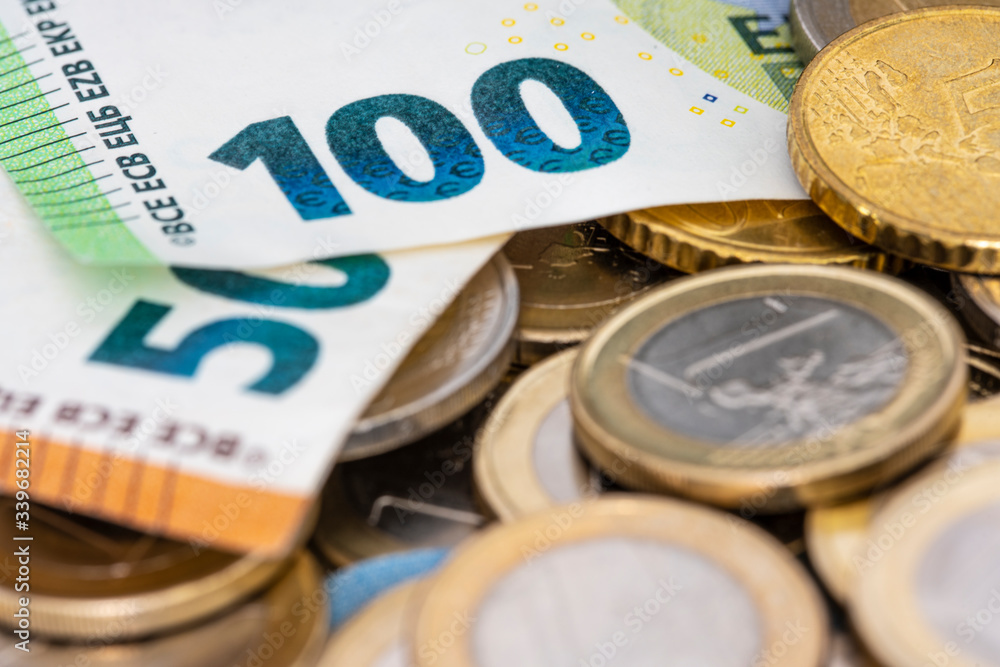 Closeup of Euros in paper and metal form. Coins and bills. Hundred Euro and 50 Euro. Closeup of Euros in paper and metal form. Coins and bills. Hundred Euro and 50 Euro.