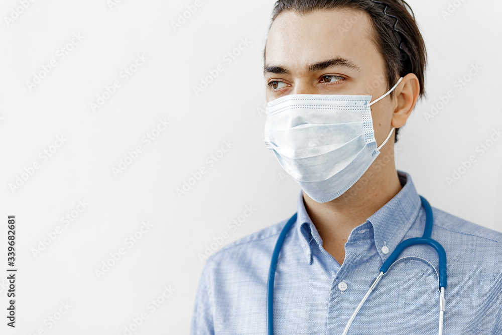 portrait of a doctor in a protective mask with a stethoscope on a white background portrait of a doctor in a protective mask with a stethoscope on a white background