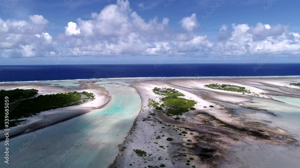 Beautiful drone pan of the turquoise blue water of the paradise island Tikehau lagoon, French Polynesia. The South Pacific ocean with clouds, blue sky fill the scenic Pink beach landscape Beautiful drone pan of the turquoise blue water of the paradise island Tikehau lagoon, French Polynesia. The South Pacific ocean with clouds, blue sky fill the scenic Pink beach landscape
