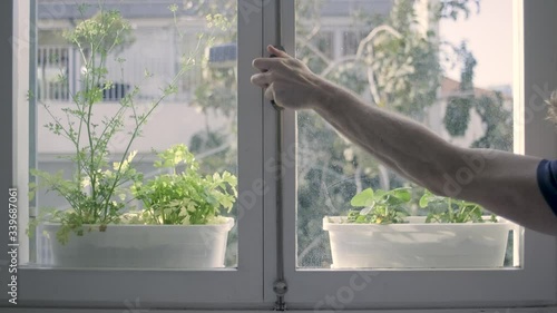 Closing a window. mans hand shutting the glass window