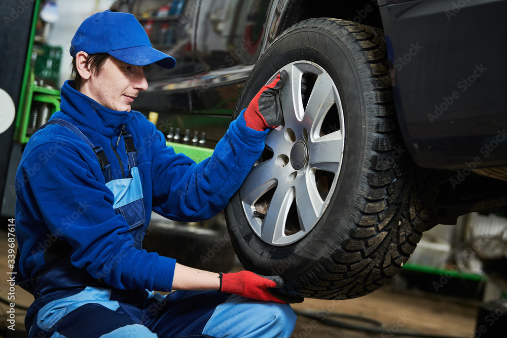 Auto service. Worker screwdriving an automobile wheel. Break maintenance or tyre replace Auto service. Worker screwdriving an automobile wheel. Break maintenance or tyre replace