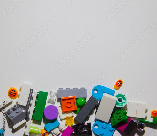 Colored toy bricks for kids on white background. Playing in plastic blocks concept. Pieces and elements of constructor