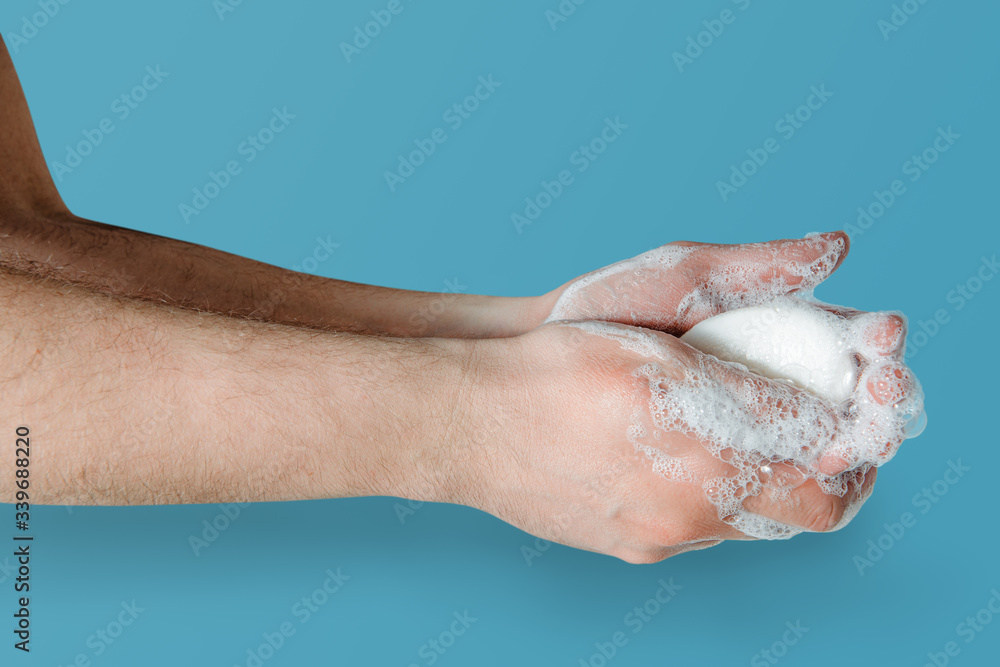 Fototapeta premium Washing hands with soap. Medical and pharmaceutical concept. Protection against viruses, bacteria, germs. Washing hands with antibacterial soap, getting rid of dirt, fighting an epidemic.