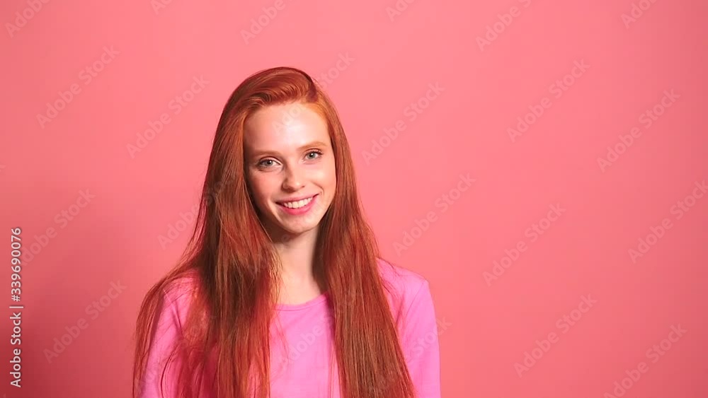 redhaired ginger woman in pink studio background smile and feeling good redhaired ginger woman in pink studio background smile and feeling good