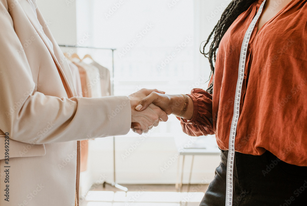 Fashion designer shaking hands with a client Fashion designer shaking hands with a client