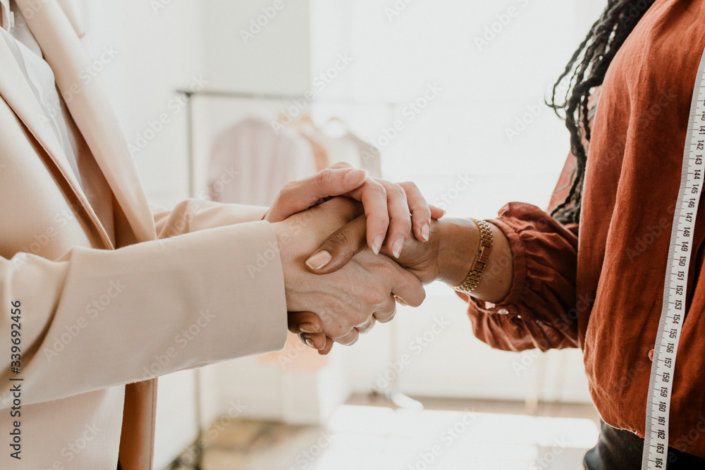 Fashion designer shaking hands with a client Fashion designer shaking hands with a client