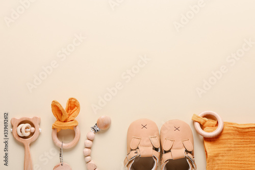 Set of baby shoes, toys and accessories on beige background. Fashion newborn stuff. Flat lay, top view
