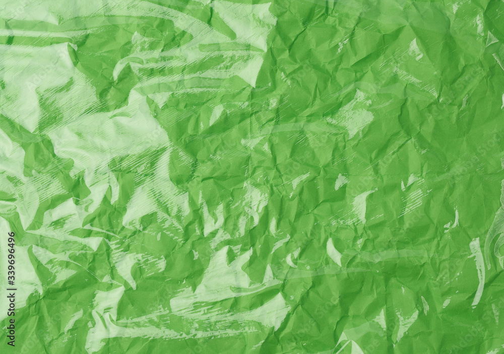 Fototapeta premium texture of a transparent stretching plastic film for packaging products on a green background