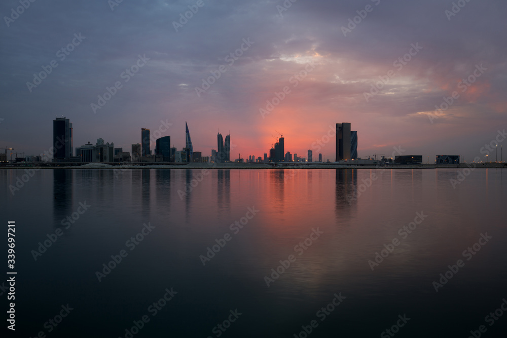 Bahrain skyline at sunset with reddish overcast sky, HDR