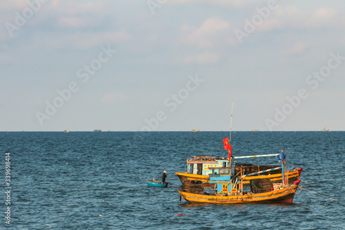 01.05.2015  Phan Thiet  Vietnam. brightly colored fishing boat sailing along the shore on background of horizon line.