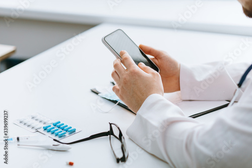 Young handsome doctor in gloves with patient online consultate photo