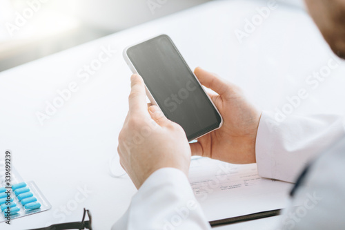 Young handsome doctor in gloves with patient online consultate photo