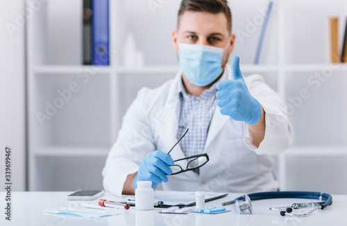 Happy man doctor in cabinet with good finger sign
