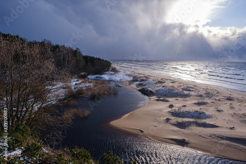 The coast of the Baltic Sea with waves and blue skies with white clouds