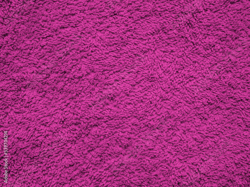 Close-up of purple textile texture, background and wallpaper. Texture of purple knitted fabric. Surface of a fleece towel. Texture of lilac fabric textile upholstery of furniture. High-quality macro.