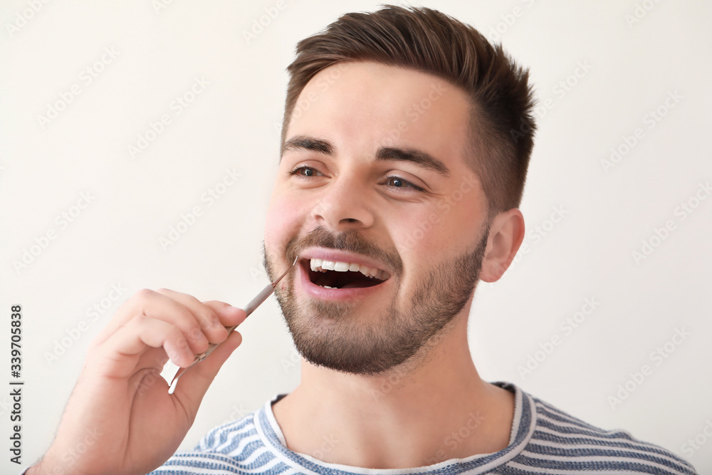 Happy smiling young man with dentist's tool on white background Happy smiling young man with dentist's tool on white background