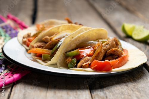 Mexican chicken fajitas tacos on wooden background