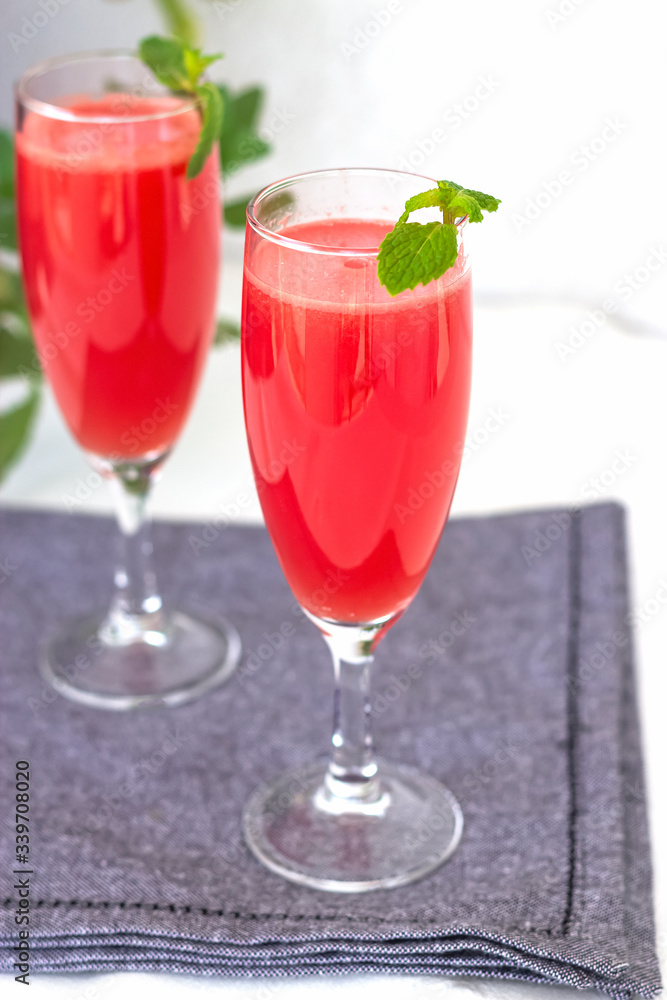 Watermelon or strawberry mojito drink with mint. Grey napkin background. Selective focus. Watermelon or strawberry mojito drink with mint. Grey napkin background. Selective focus.