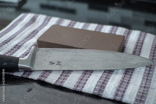 Картината върху платно Knife Sharpening on Wet Whetstone , Santoku chef knife close up