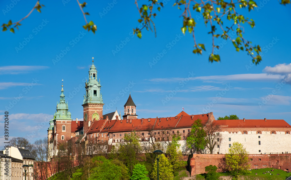 Riverside of Krakow City in Poland with Wawel castle view from across the river Vistula with people, tourists, enjoying fine Spring sunny weather Riverside of Krakow City in Poland with Wawel castle view from across the river Vistula with people, tourists, enjoying fine Spring sunny weather