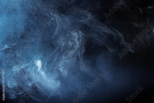 Blue smoke over black studio background