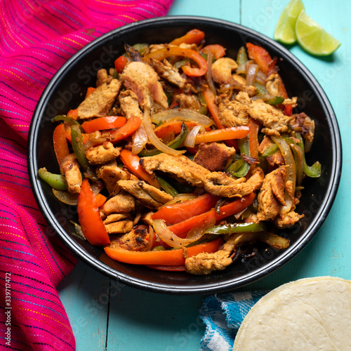 Mexican chicken fajitas on turquoise background