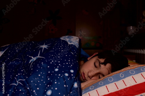 Billede på lærred a Caucasian boy sleeps in the bed of his bedroom