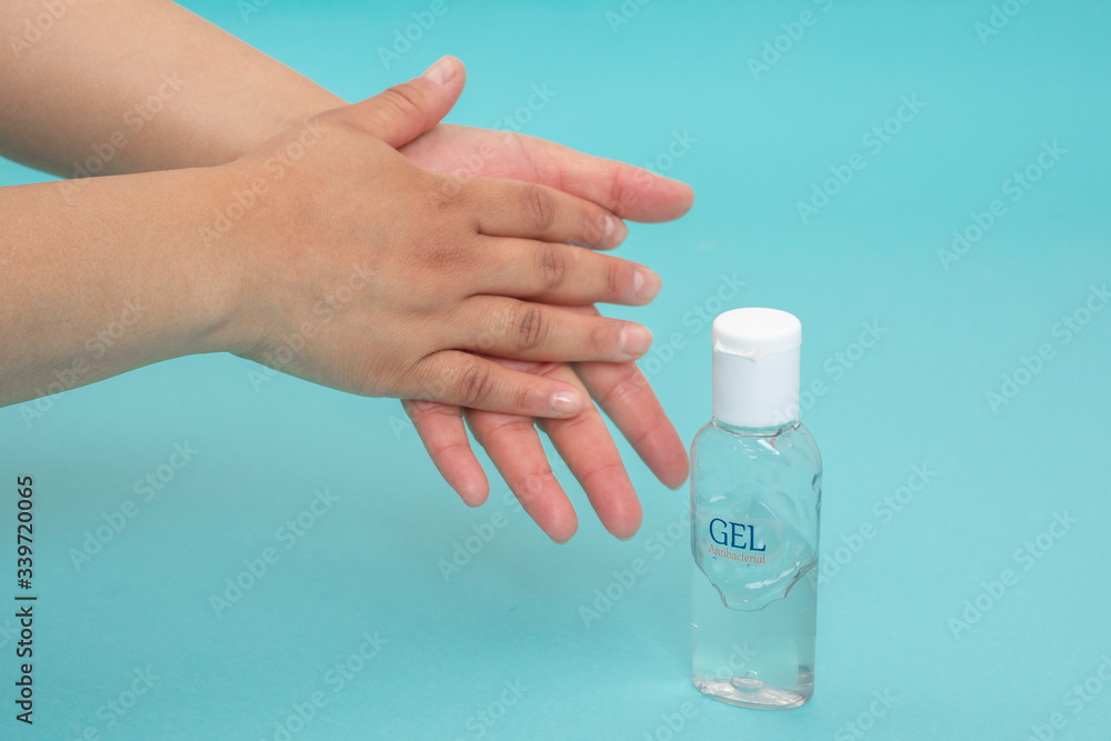 Desinfección de manos con gel antibacterial sobre un fondo de color azul Desinfección de manos con gel antibacterial sobre un fondo de color azul