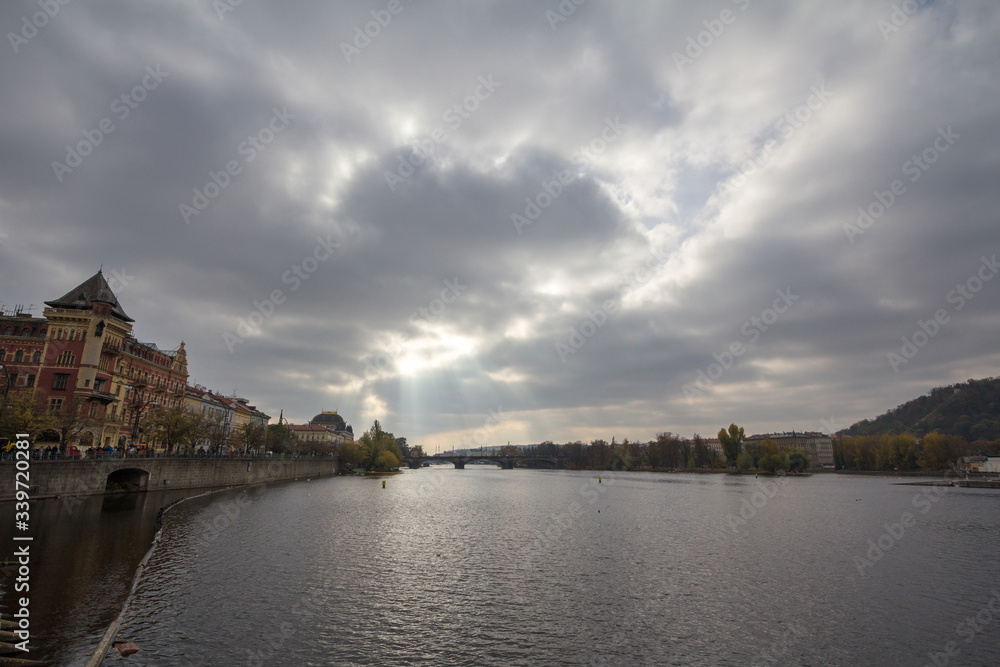 Panorama of Prague, Czech Republic, seen from the Vltava river, also called Moldau, with Most Legii, or Legion Most, one of the landmarks of the city in background, during a cloudy sunset in autumn