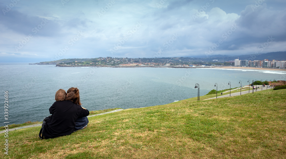 Gijon, Asturias. Spain. 
Two lovers enjoy the views of the sea on top of a park on a cloudy day in Gijon, Spain.