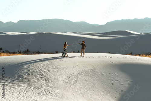 A couple dancing on sand dunes in the desert