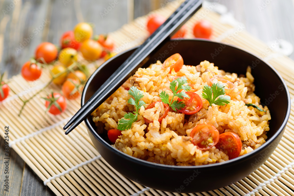 Fried rice with minced pork and tomato in a bowl and chopsticks ready to eating, Asian food Fried rice with minced pork and tomato in a bowl and chopsticks ready to eating, Asian food