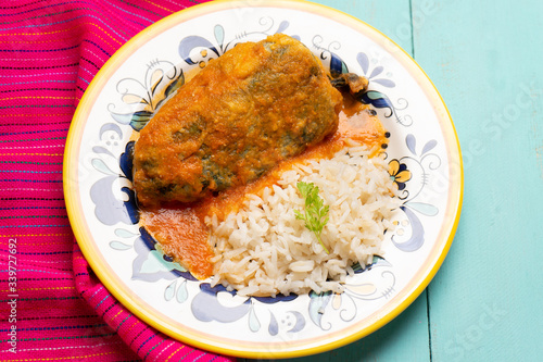 Mexican chili-stuffed poblano with rice on turquoise background