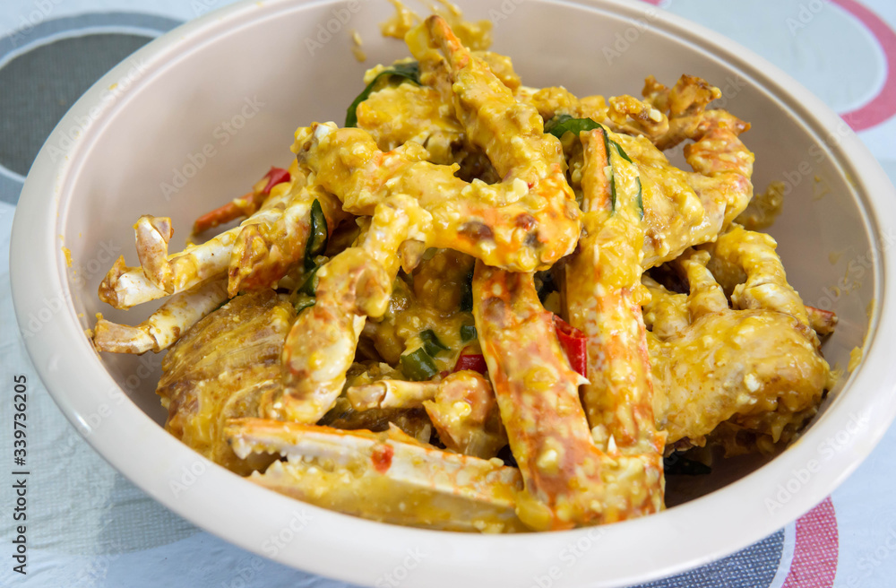 Close up view of buttermilk crab mixed with salted duck eggs in a white bowl. Close up view of buttermilk crab mixed with salted duck eggs in a white bowl.