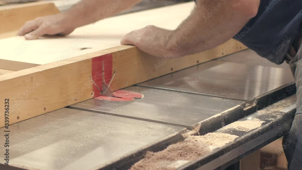 A carpenter uses a circular saw in a workshop A carpenter uses a circular saw in a workshop